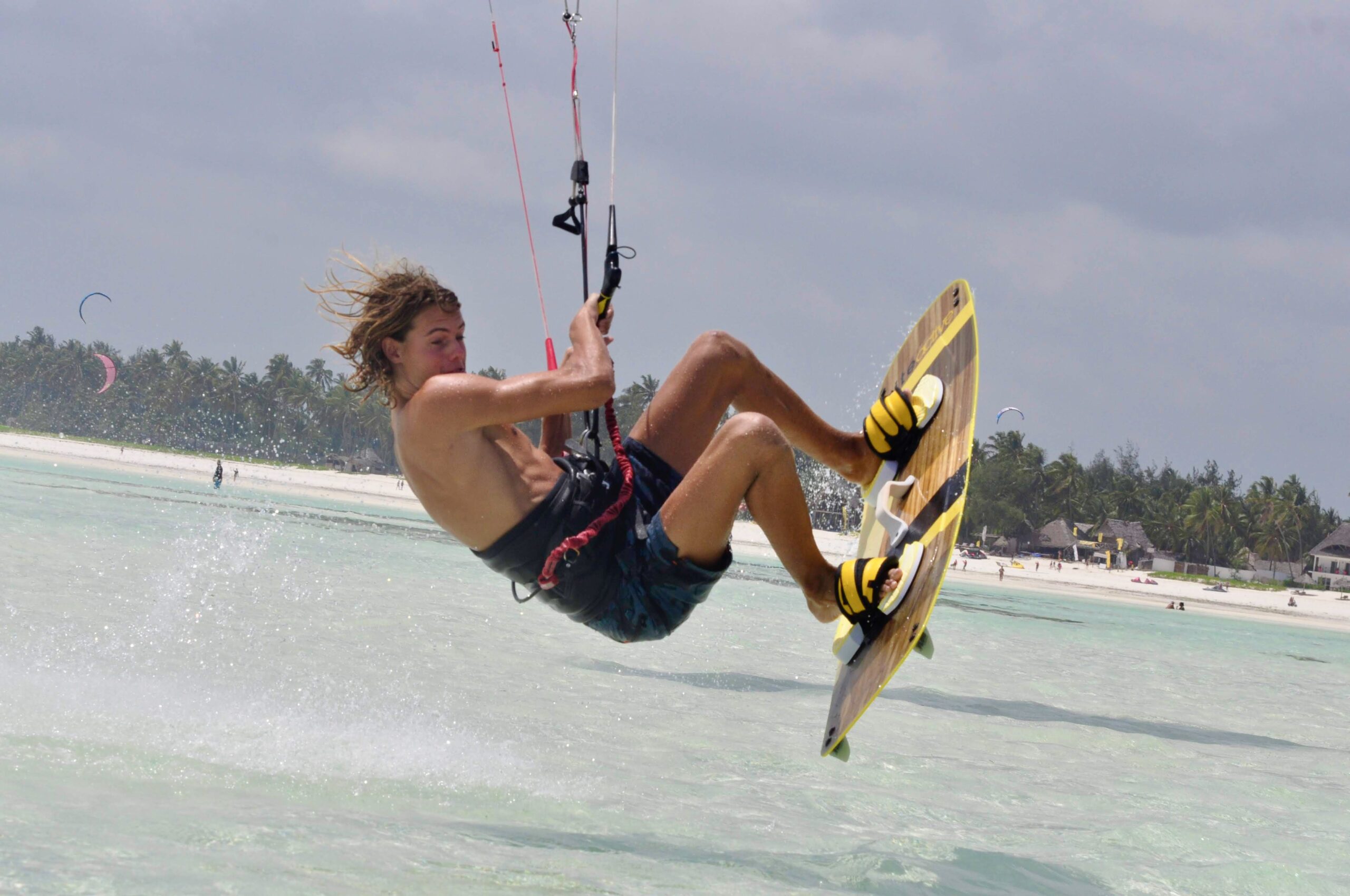 Kitesurfer in actie tijdens een sprong op het heldere water van Zanzibar.
