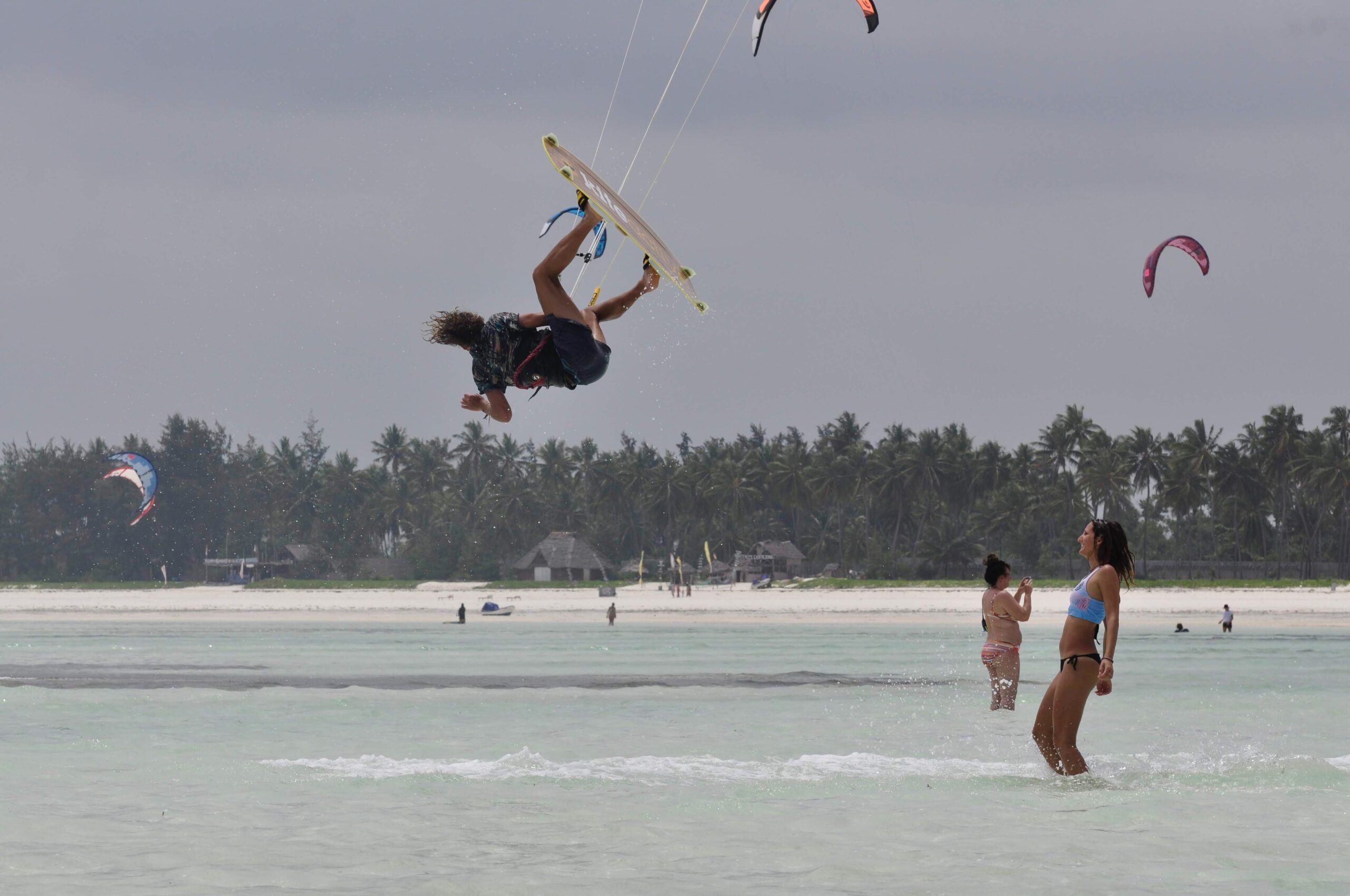 Kitesurfer in actie tijdens een sprong op het heldere water van Zanzibar.