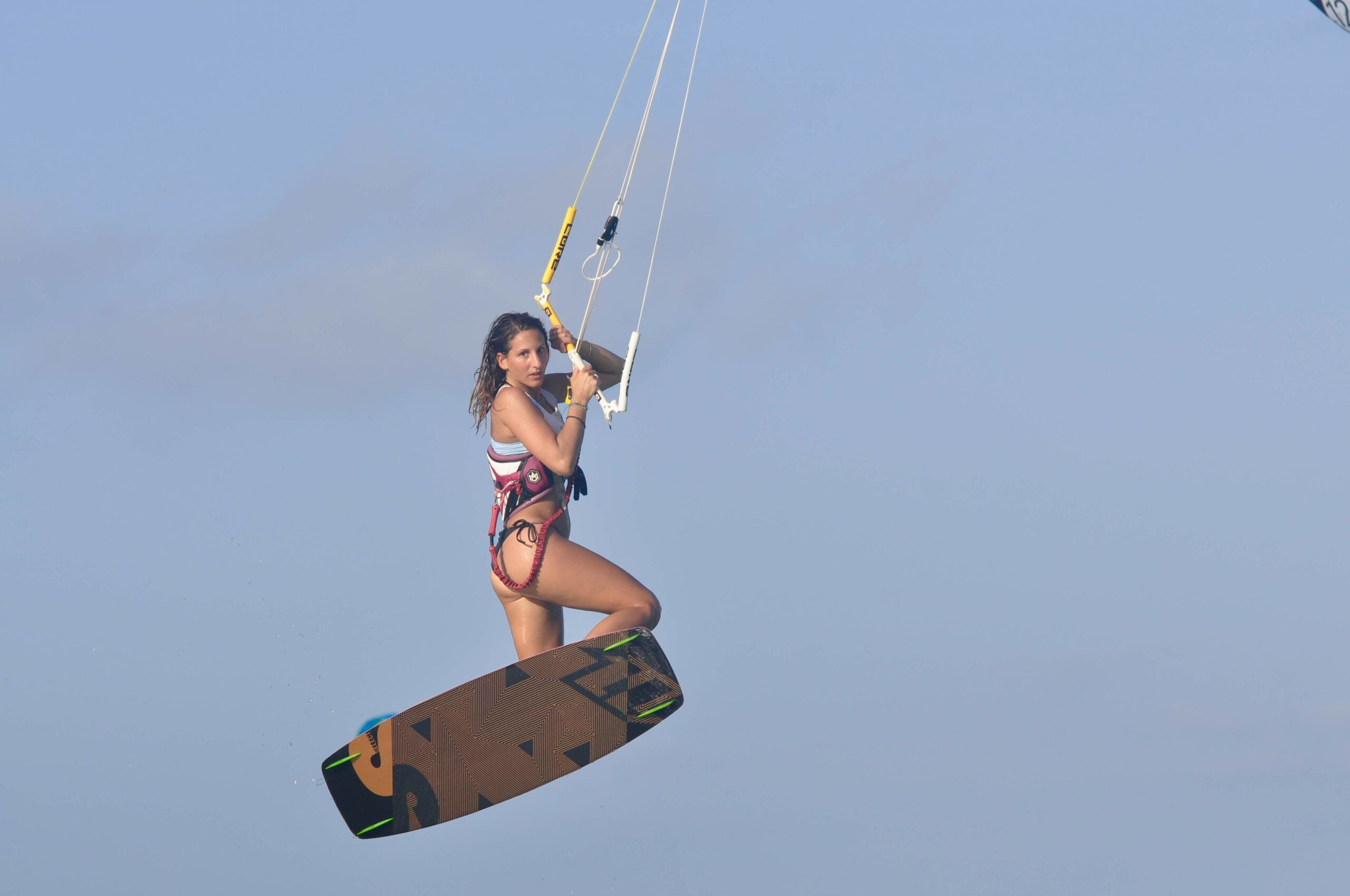 Kitesurfster in actie tijdens een sprong op het heldere water van Zanzibar.